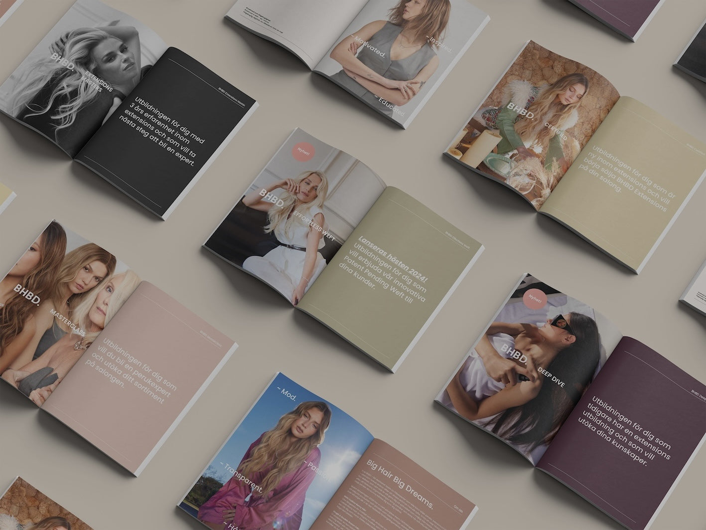An overhead flat-lay view of multiple open fashion magazines or brochures arranged on a neutral beige surface. The pages feature editorial photos of women in various outfits and neutral-toned layouts.