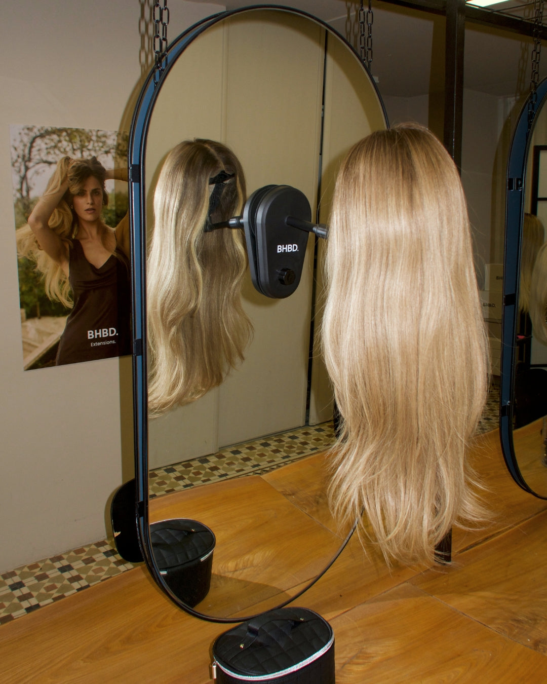 travel wig stand attached to a mirror with a wig on